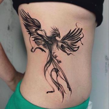 Black linework phoenix tattoo on lower back