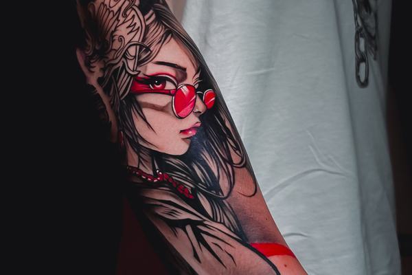 Red and black portrait forearm tattoo