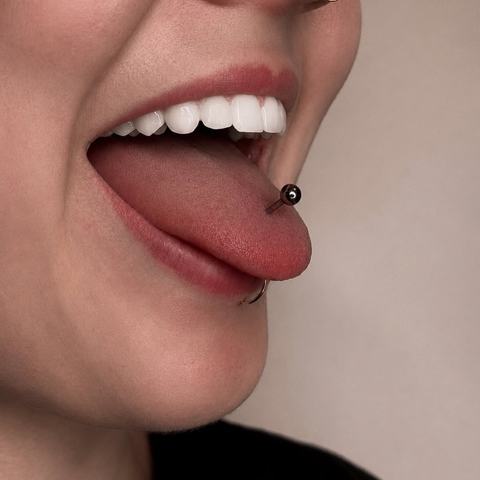 Distinctive tongue piercing with minimalist jewellery that adds a bold and individual detail to the overall look.