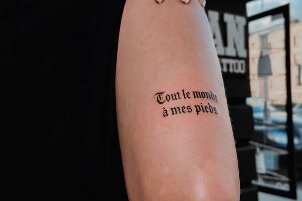 Text tattoo above the knee