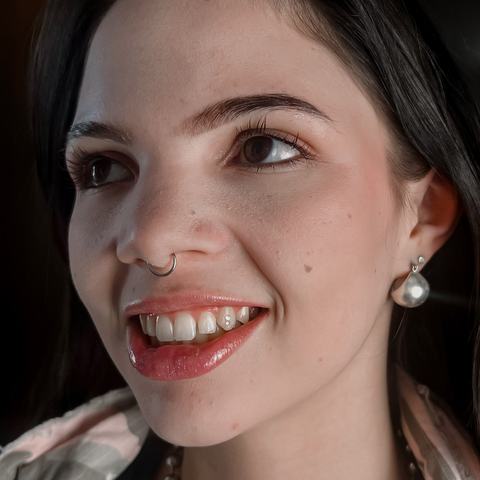 Septum piercing with minimalist jewellery that highlights facial symmetry and adds a bold, distinctive detail to the overall look.