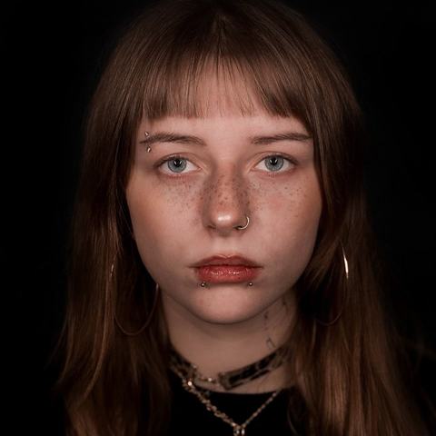 Lower lip piercing highlights the lip contour and adds a clean, expressive detail to the overall look.